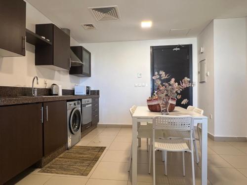 a kitchen with a white table and a sink at Spacious apartments with Sea view at Samarah Resort in Sowayma