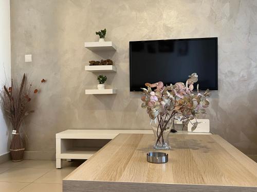 a living room with a vase of flowers on a table at Spacious apartments with Sea view at Samarah Resort in Sowayma