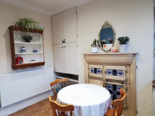 a dining room with a white table and chairs at Entire house Sheffield s10booking in Stannington