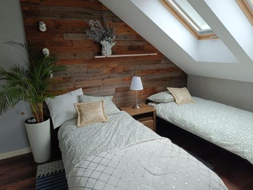 two beds in a room with a attic at Kaszubski Biegun One in Szumles Szlachecki