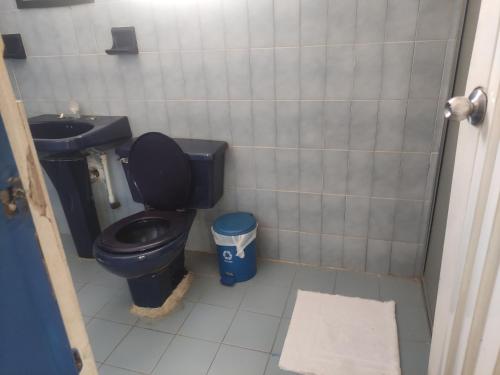 baño con aseo negro y lavamanos en Hotel Marqués de San Luis, en Melgar
