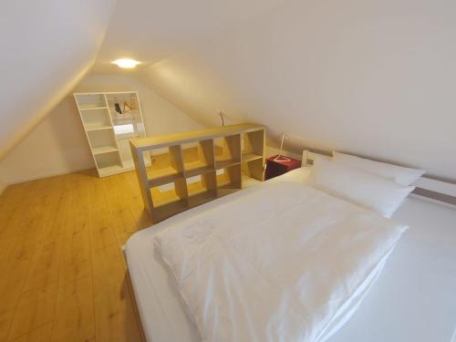 ein Schlafzimmer mit einem weißen Bett im Dachgeschoss in der Unterkunft Gerritz+Gäste in Meerbusch