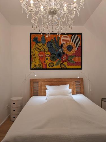 a bedroom with a large bed with a chandelier at Gerritz+Gäste in Meerbusch