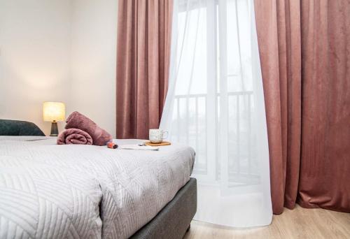 a bedroom with a bed and a window with curtains at Apartament Łowca Snów in Chełm