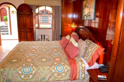 a bedroom with a bed with a wooden head board at El Tucano Resort & Thermal Spa in Quesada