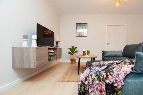 a living room with a couch and a flat screen tv at Apartament Łowca Snów in Chełm