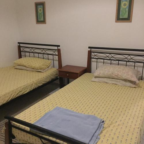 a bedroom with two beds and a blue towel on the bed at Private villa North Coast in Dawwār Muḩammad Abū Shanab