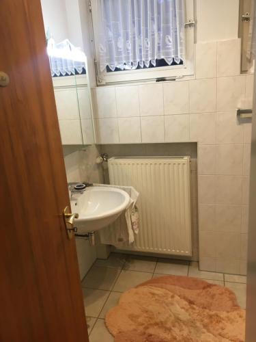 ein kleines Bad mit einem Waschbecken und einem Fenster in der Unterkunft My vintage Home in Solingen