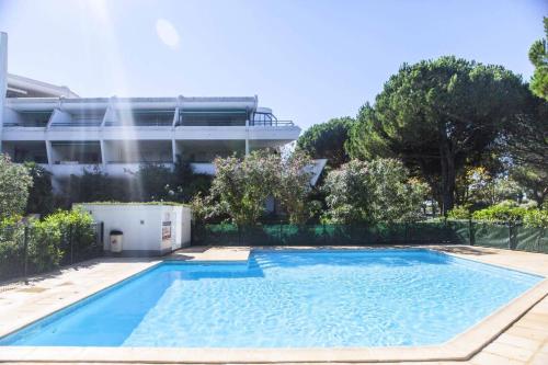 une piscine devant un immeuble dans l'établissement Villegiales Tee2 - Bel appartement en rez-de-jardin vue Ponant MAE-1144, à La Grande Motte