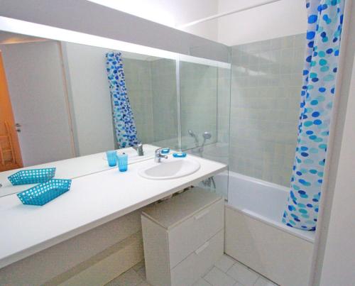 une salle de bain avec un lavabo et une baignoire dans l'établissement Villegiales Tee2 - Bel appartement en rez-de-jardin vue Ponant MAE-1144, à La Grande Motte