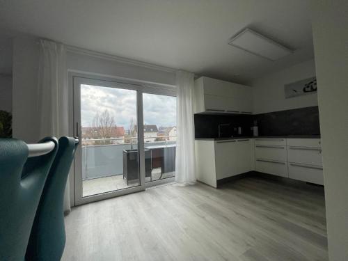 uma cozinha com uma grande porta de vidro deslizante e uma varanda em Moderne Apartments in zentraler Lage em Filderstadt