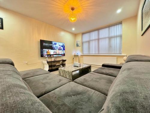 a living room with a couch and a flat screen tv at Full Home in Heywood Street near Cheetham Hill in Manchester
