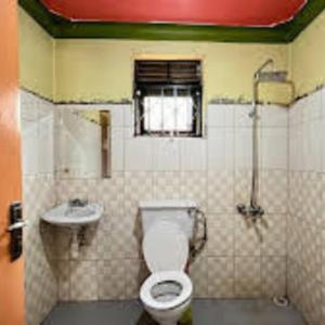 a bathroom with a toilet and a sink at Royal Lake View Hotel in Kampala