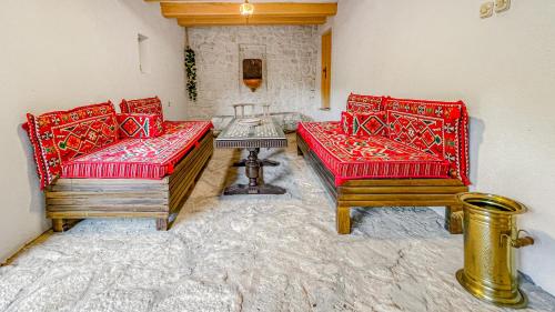 um quarto com dois sofás vermelhos e uma mesa em Villa Historic Pocitelj with pool and incredible views on the river and landmarks em Počitelj
