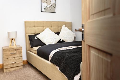um quarto com uma cama com uma mesa de cabeceira ao lado em Everest Home em Nottingham