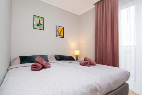ein Schlafzimmer mit einem Bett mit roten Kissen darauf in der Unterkunft Apartament Łowca Snów in Chełm