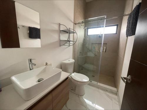 a bathroom with a sink and a toilet and a shower at Casa Santacruz in Ensenada