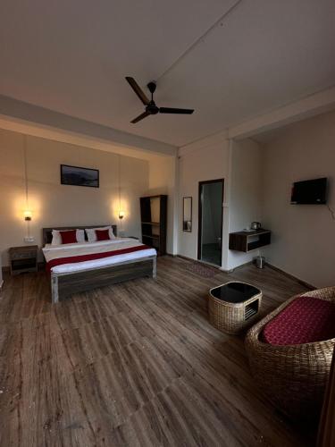 ein Schlafzimmer mit einem Bett, einem Sofa und einem Ventilator in der Unterkunft Majestic Zen Farmstay in Darjeeling