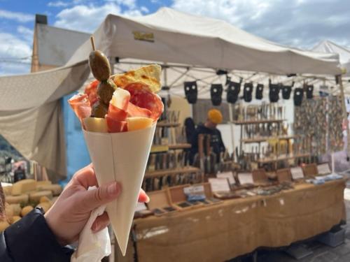 a person holding up a cone of food in front of a market at Casa vacanze “Dolce sosta” in Quartu SantʼElena