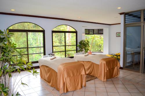 two beds in a room with large windows at El Tucano Resort & Thermal Spa in Quesada
