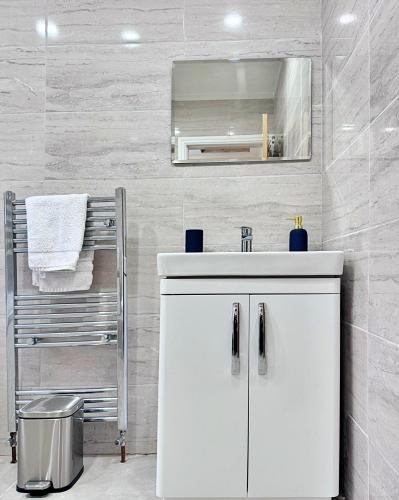 a bathroom with a white sink and a mirror at Full Home in Heywood Street near Cheetham Hill in Manchester