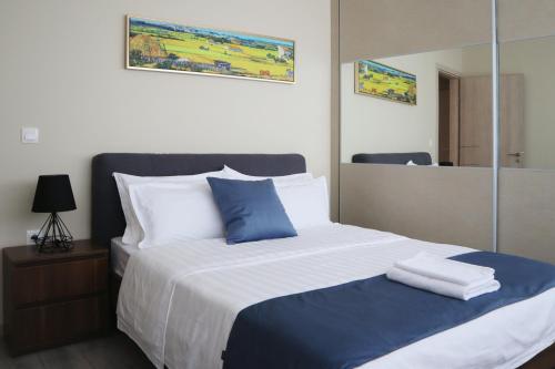 a bed with blue and white pillows and a mirror at Dafni City Apartment 2 in Athens