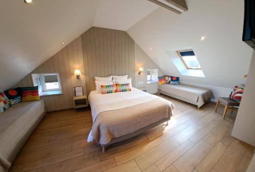 a large bedroom with a bed and a couch at La Maison Du 6 in Arromanches-les-Bains