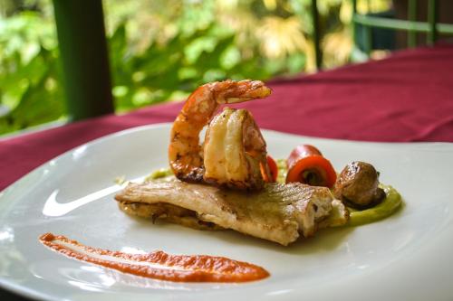 a plate of food with meat and shrimp on it at El Tucano Resort & Thermal Spa in Quesada