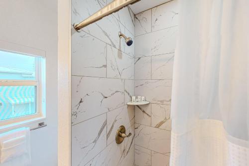 a bathroom with a shower with white marble walls at La Nereida in Marathon