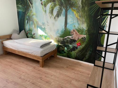 ein Schlafzimmer mit einem Wandbild eines Dschungels in der Unterkunft Ferienwohnung Durchholz in Steinhude
