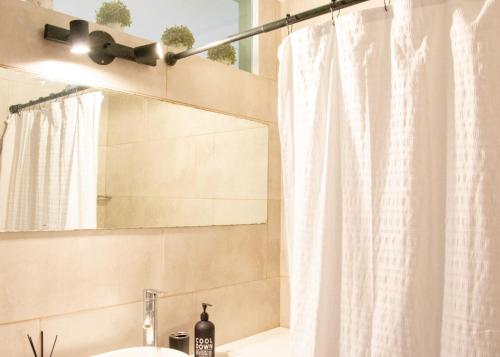 a bathroom with a shower curtain and a sink at Moreno home in La Plata