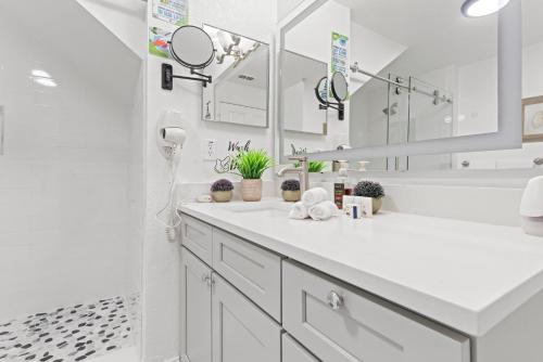 a white bathroom with a sink and mirrors at The Villas at Seven Dwarfs - 4564 Luxury Villa - Near Disney - Water Park in Kissimmee
