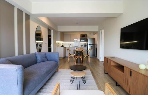 a living room with a blue couch and a table at Pod by Wynwood House in Lima