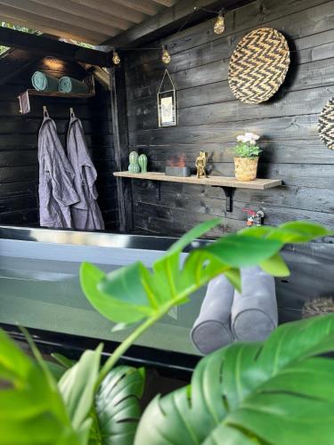 a bathtub in a room with wooden walls at De Rolders in Wapenveld