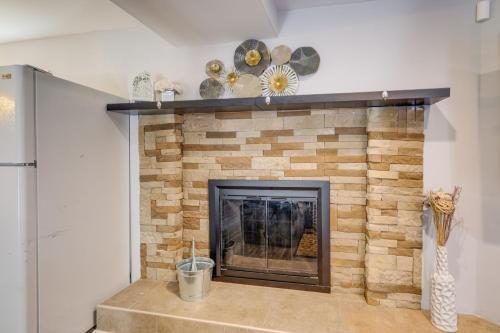 a brick fireplace with a wooden mantel and a clock at Pet-Friendly Woodbridge Retreat Near Potomac Mills in Woodbridge