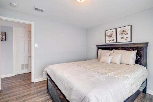 a bedroom with a large bed with two pictures on the wall at Pet-Friendly Woodbridge Retreat Near Potomac Mills in Woodbridge