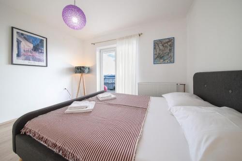 a bedroom with a bed with two towels on it at Sunset Apartments in Crikvenica