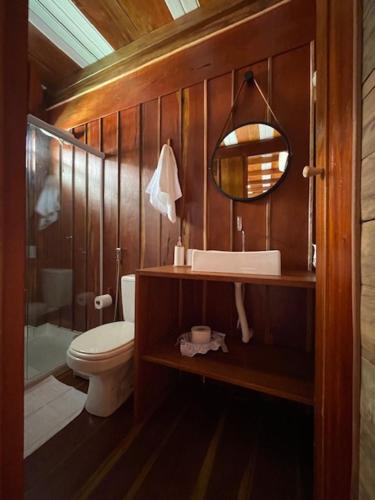 W łazience znajduje się toaleta, umywalka i lustro. w obiekcie Chalés Mãe Natureza w mieście Itaparica