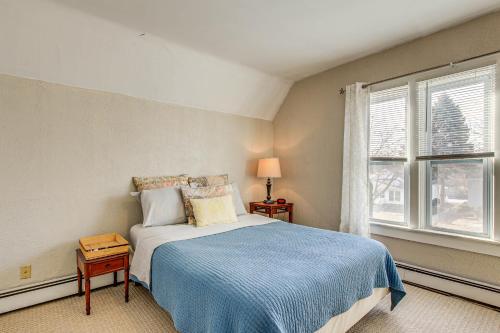 ein Schlafzimmer mit einem Bett mit einer blauen Decke und einem Fenster in der Unterkunft Dog-Friendly Green Bay Home, 1 Mi to Downtown! in Green Bay