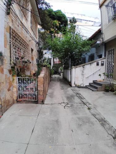 an empty alley with a fence and a building at Quarto em Villa Jardim Botânico in Rio de Janeiro