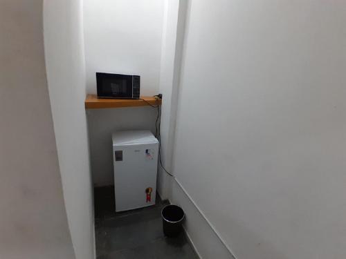 een kleine kamer met een kleine koelkast en een magnetron bij Quarto em Villa Jardim Botânico in Rio de Janeiro