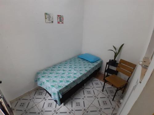 1 dormitorio pequeño con 1 cama y 1 silla en Quarto em Villa Jardim Botânico, en Río de Janeiro