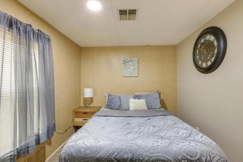 a bedroom with a bed with a clock on the wall at Cozy Morriston Home Near World Equestrian Center! in Morriston