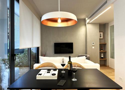 a living room with a table and two glasses of wine at AIONION RESIDENCES by K&K in Athens