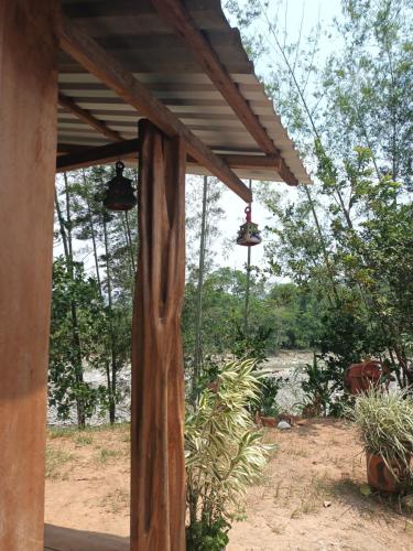 a wooden pergola with two bells hanging from it at Hostal La Cabaña in Mesetas