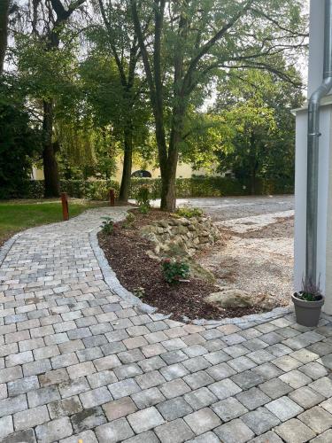 a brick walkway with a tree in a park at Gut Schwarz-n Hof Ferienwohnungen in Bad Griesbach