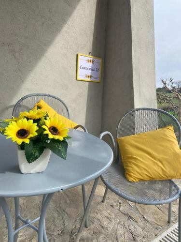 a table with a vase of sunflowers and a yellow pillow at Casa civico22 in Fratta Todina