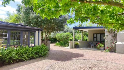 a house with a patio and a garden at Blissful Country Garden Self-Catering Cottage in Grabouw