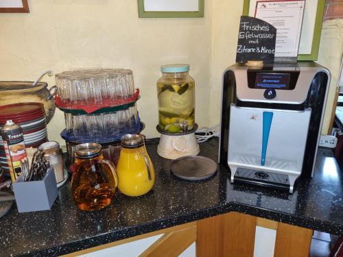 a kitchen counter with a blender and a juicer and juice at Gästehaus St. Martin in Ulmen