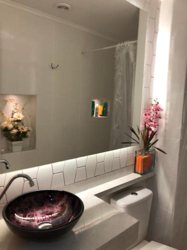 ein Badezimmer mit einem Waschbecken, einem Spiegel und einem WC in der Unterkunft Vivaz transamerica in São Paulo